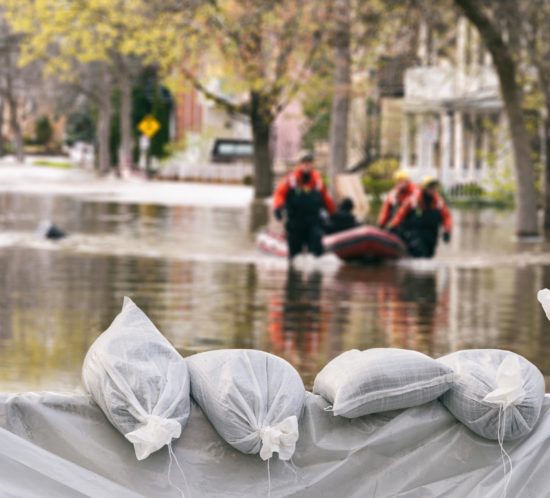 Flood Protection Sandbags with flooded homes in the background (Montage)