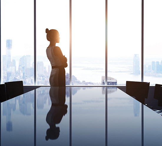 A businesswoman looking out the window of her office - Lagentium Insurance Brokers