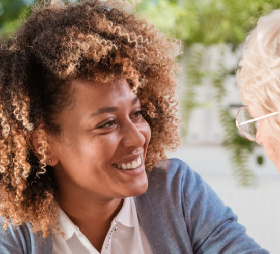 Friendly nurse supporting an eldery lady - Lagentium Insurance Brokers