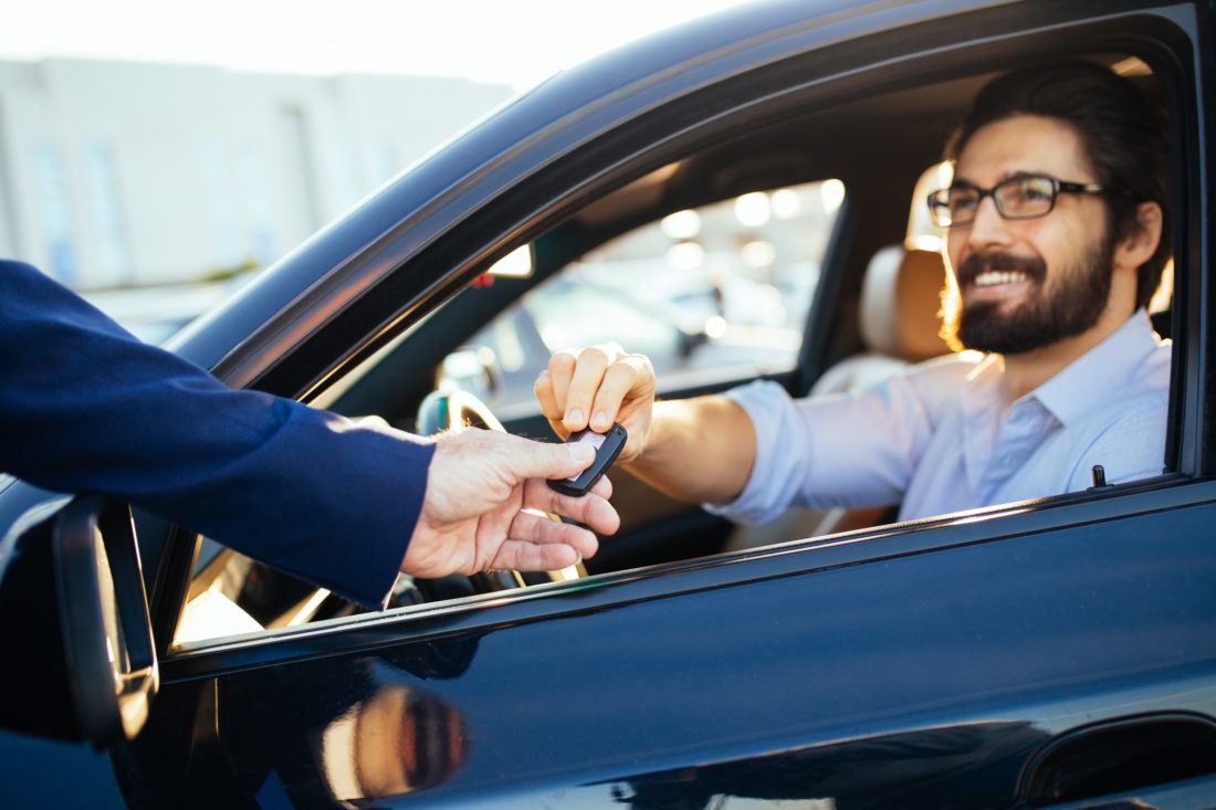 Young handsome businessman buying car