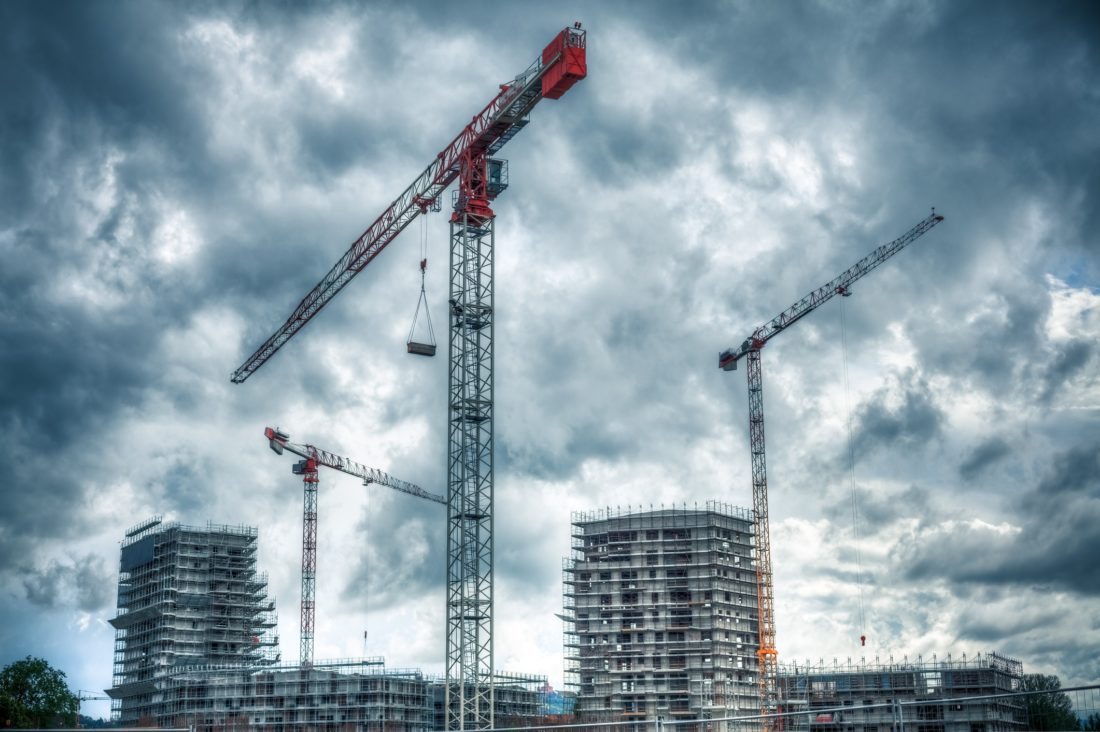 Construction Site with Cranes and Cloudy Sky