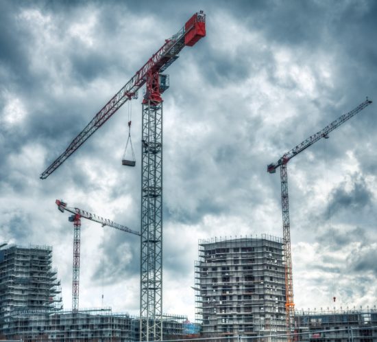Construction Site with Cranes and Cloudy Sky